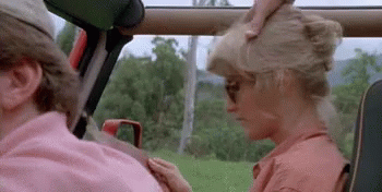 A Man And A Woman Are Sitting In A Car . The Woman Is Wearing Sunglasses And A Pink Shirt . GIF