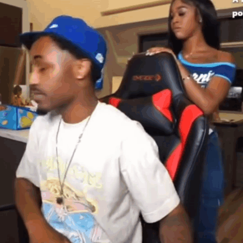 A Man And A Woman Are Sitting In A Chair . GIF