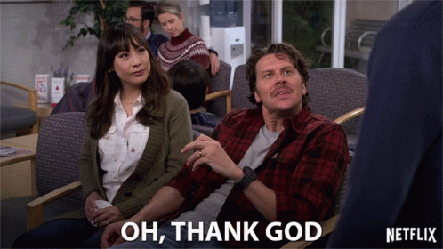 A Man And A Woman Are Sitting In A Waiting Room With The Words Oh Thank God Above Them GIF