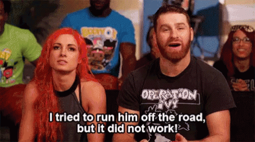 A Man And A Woman Are Sitting In Front Of A Crowd . The Man Is Wearing A Shirt That Says Operation Ivy GIF