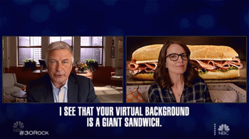 A Man And A Woman Are Sitting In Front Of A Giant Sandwich On A Nbc Screen GIF