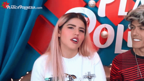 A Man And A Woman Are Sitting In Front Of A Sign That Says " Poli " GIF