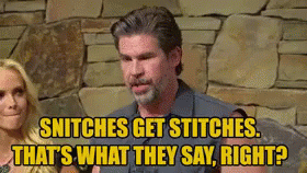 A Man And A Woman Are Sitting In Front Of A Stone Wall . GIF