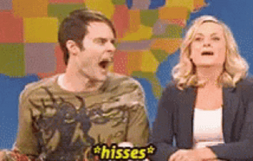 A Man And A Woman Are Sitting Next To Each Other And One Of Them Is Saying Hiisses GIF