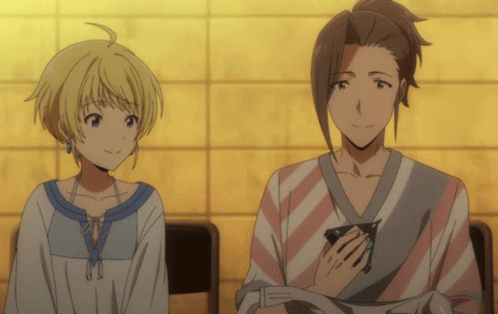 A Man And A Woman Are Sitting Next To Each Other And Smiling GIF