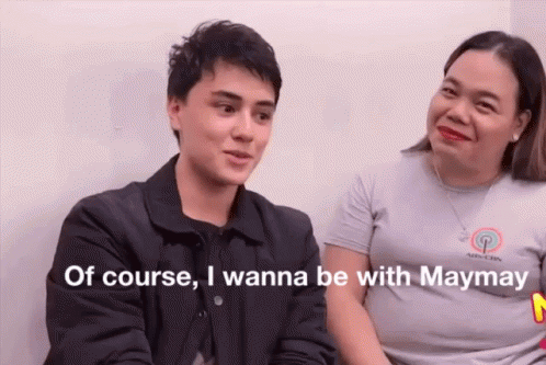 A Man And A Woman Are Sitting Next To Each Other And Talking . The Man Is Talking About Being With Maymay . GIF