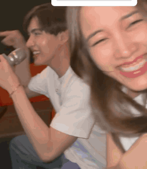 A Man And A Woman Are Sitting Next To Each Other And The Woman Is Smiling GIF