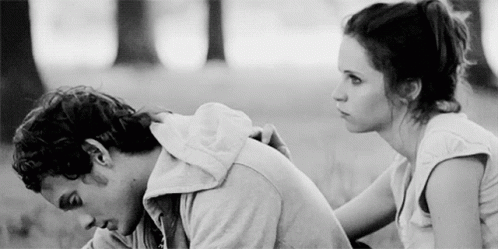 A Man And A Woman Are Sitting Next To Each Other In A Black And White Photo . GIF