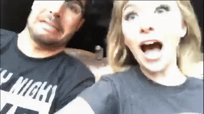 A Man And A Woman Are Sitting Next To Each Other In A Car And The Woman Is Screaming . GIF