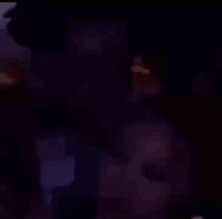 A Man And A Woman Are Sitting Next To Each Other In A Room . GIF