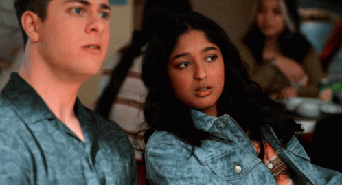 A Man And A Woman Are Sitting Next To Each Other In A Room GIF