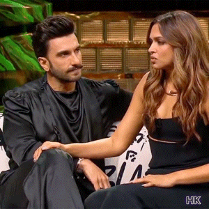 A Man And A Woman Are Sitting Next To Each Other On A Couch And Talking To Each Other . GIF