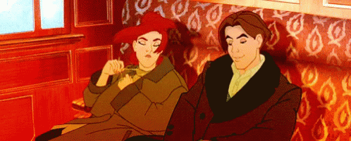A Man And A Woman Are Sitting Next To Each Other On A Couch GIF