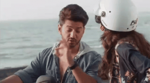 A Man And A Woman Are Sitting Next To Each Other On A Motorcycle . GIF