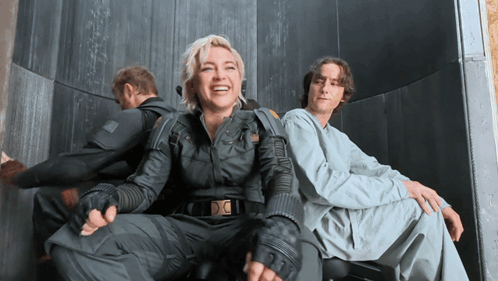A Man And A Woman Are Sitting Next To Each Other GIF