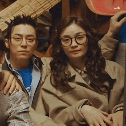 A Man And A Woman Are Sitting Next To Each Other With The Letters Lje On The Bottom Right GIF