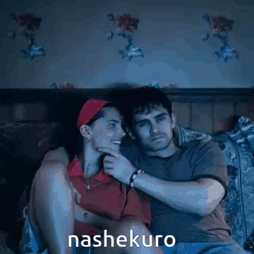 A Man And A Woman Are Sitting On A Bed And The Word Nashekuro Is On The Bottom Right GIF