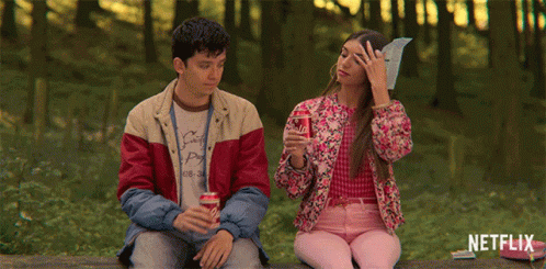 A Man And A Woman Are Sitting On A Bench With Netflix Written On The Bottom GIF