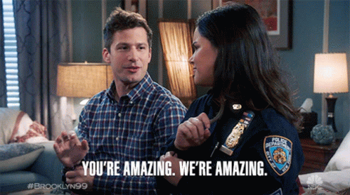 A Man And A Woman Are Sitting On A Couch And The Woman Is Wearing A Badge That Says New York Police Department GIF