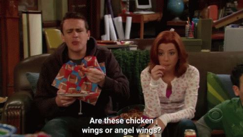 A Man And A Woman Are Sitting On A Couch Eating Chicken Wings And The Woman Asks Are These Chicken Wings GIF