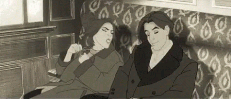A Man And A Woman Are Sitting On A Couch Together . GIF