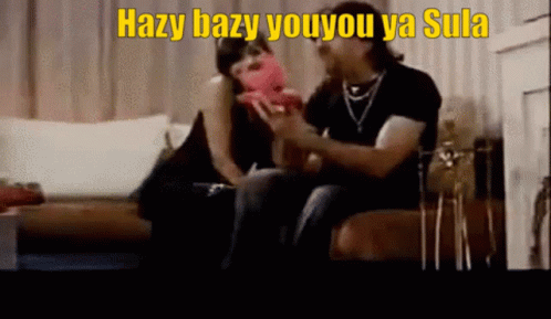 A Man And A Woman Are Sitting On A Couch With Hazy Bazy Youyou Ya Sula Written On The Bottom GIF