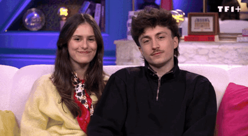 Man And Woman Sitting On Couch With TFI Plus GIF