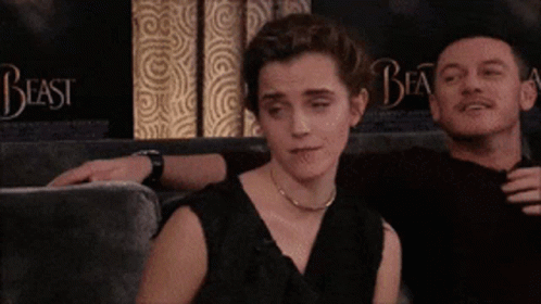A Man And A Woman Are Sitting On A Couch With The Word Beast Behind Them GIF