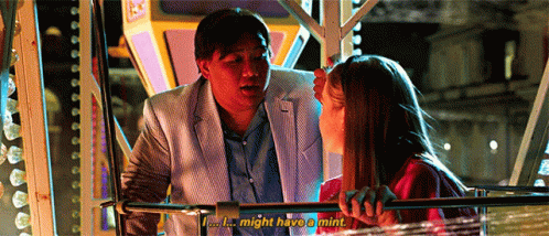A Man And A Woman Are Sitting On A Ferris Wheel And The Man Is Talking To The Woman . GIF