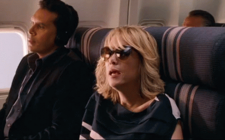 A Man And A Woman Are Sitting On A Plane . GIF