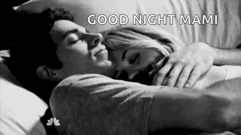 A Man And A Woman Are Sleeping In A Bed Together . GIF