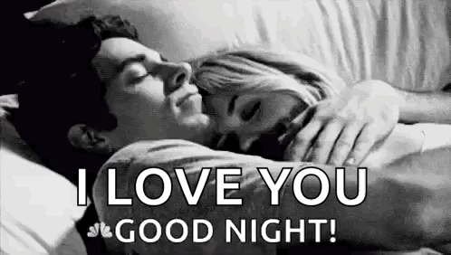 A Man And A Woman Are Sleeping In A Bed . GIF