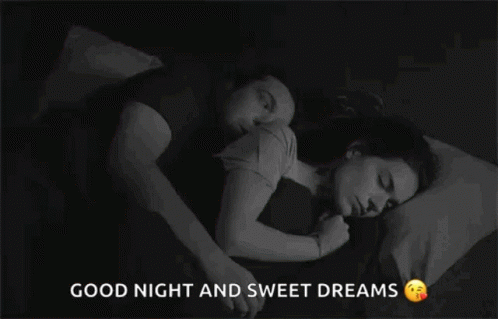 A Man And A Woman Are Sleeping Together In A Bed . GIF