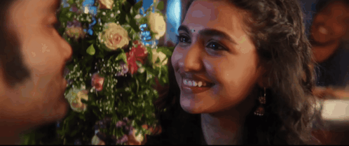 A Man And A Woman Are Smiling And Looking At Each Other GIF