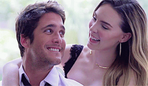 A Man And A Woman Are Smiling At Each Other GIF