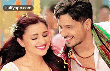 A Man And A Woman Are Smiling For The Camera . GIF