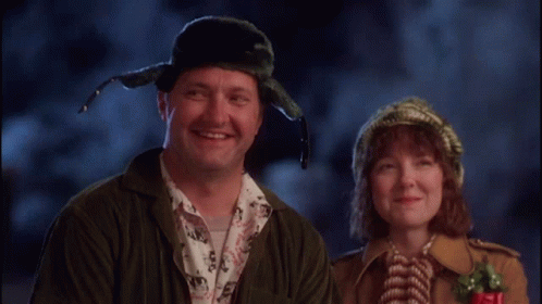A Man And A Woman Are Smiling For The Camera GIF