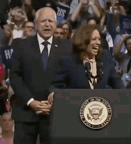 A Man And A Woman Are Standing Behind A Podium That Says President Of The United States On It . GIF