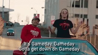 A Man And A Woman Are Standing In A Car With The Words It 'S Gameday , Gameday Gotta Get Down On Gameday GIF