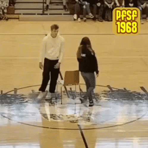 A Man And A Woman Are Standing In A Circle On A Basketball Court With The Year 1968 On The Bottom GIF