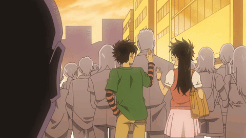 A Man And A Woman Are Standing In A Crowd GIF
