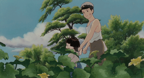 A Man And A Woman Are Standing In A Field Of Plants GIF