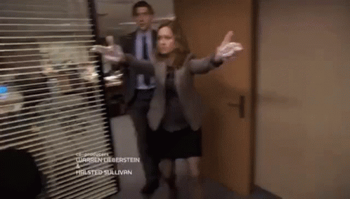 A Man And A Woman Are Standing In A Hallway With The Name Warren Lieberstein On The Bottom Of The Screen GIF