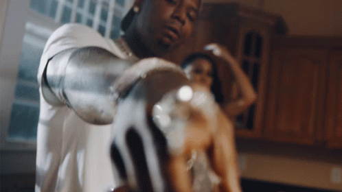 A Man And A Woman Are Standing In A Kitchen GIF