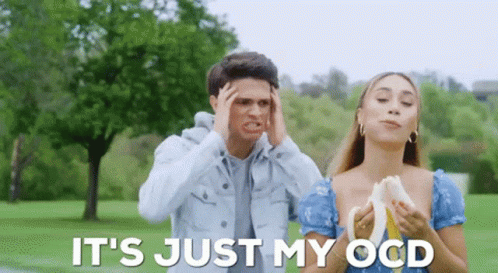 A Man And A Woman Are Standing In A Park And The Woman Is Holding A Banana . GIF