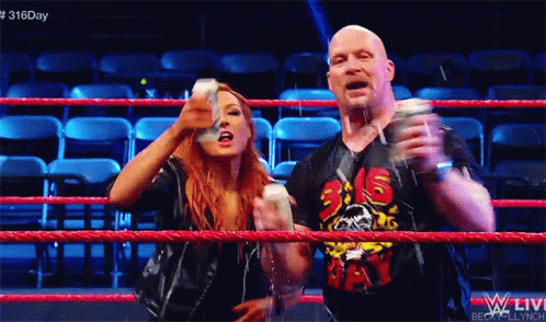 A Man And A Woman Are Standing In A Wrestling Ring With The Number 316 On Their Shirt GIF