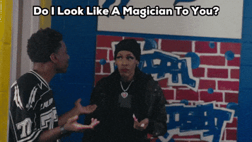 A Man And A Woman Are Standing In Front Of A Brick Wall With The Words " Do I Look Like A Magician To You " GIF
