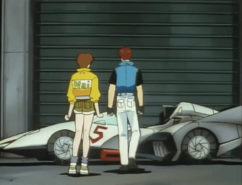 A Man And A Woman Are Standing In Front Of A Car With The Number 5 On It GIF