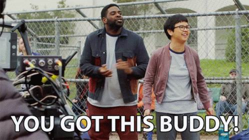 A Man And A Woman Are Standing In Front Of A Chain Link Fence With The Words You Got This Buddy Below Them GIF