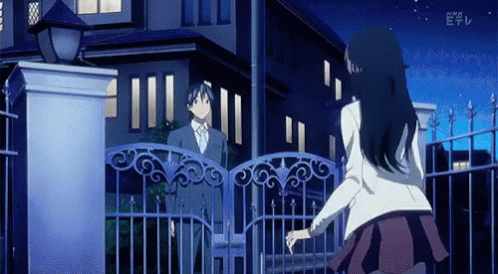 A Man And A Woman Are Standing In Front Of A Fence With The Letters E On The Bottom Left GIF